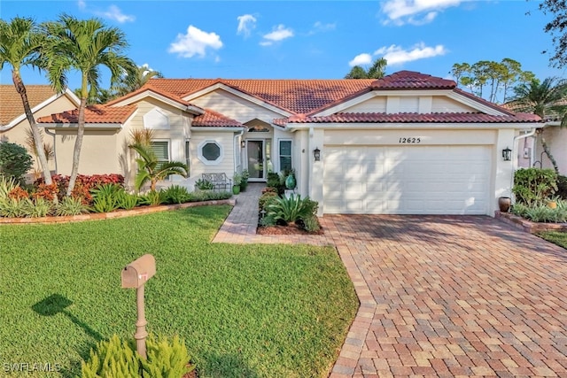 mediterranean / spanish house featuring a front yard and a garage