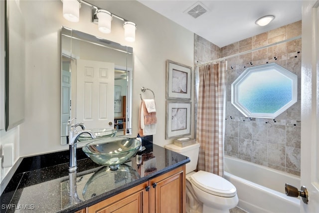 full bathroom with vanity, shower / bath combo, and toilet