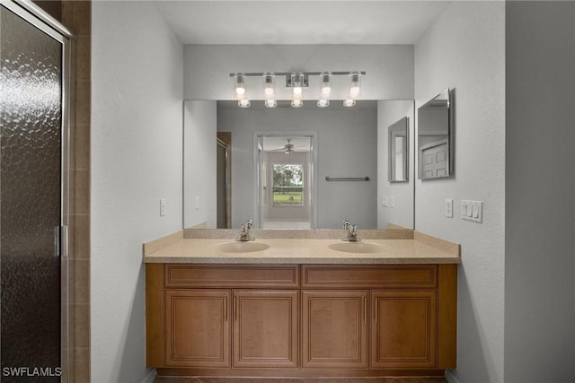 bathroom with ceiling fan, a shower with shower door, and vanity