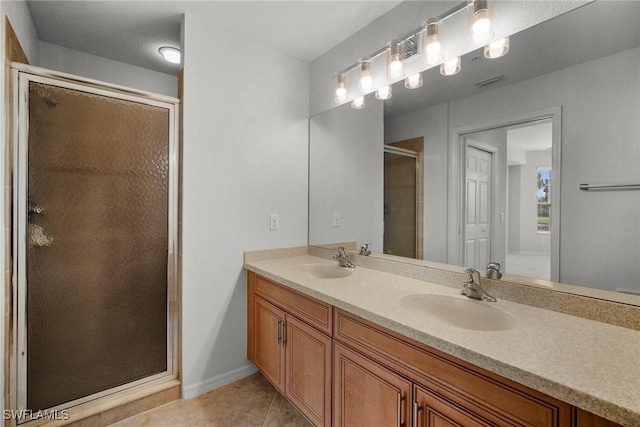 bathroom featuring tile patterned flooring, vanity, and a shower with shower door