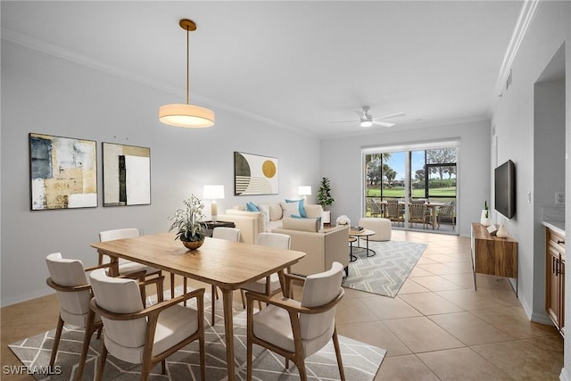 tiled dining room with ceiling fan and crown molding