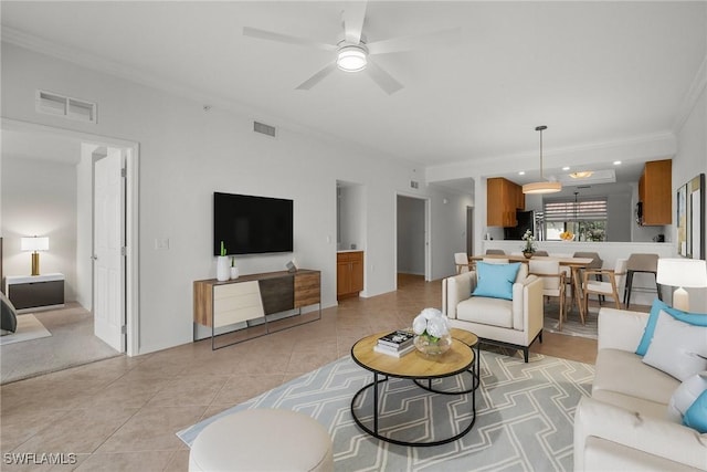 tiled living room with ceiling fan and ornamental molding