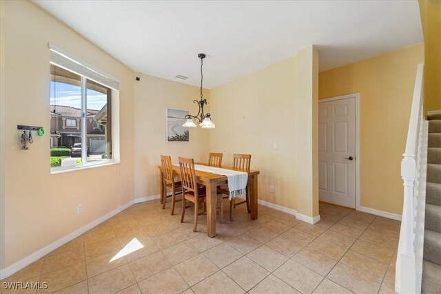 tiled dining room featuring a notable chandelier