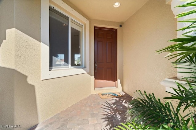 entrance to property featuring stucco siding