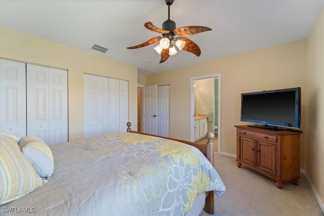 carpeted bedroom with ceiling fan, connected bathroom, and multiple closets