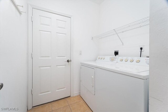 washroom with light tile patterned flooring and washing machine and clothes dryer