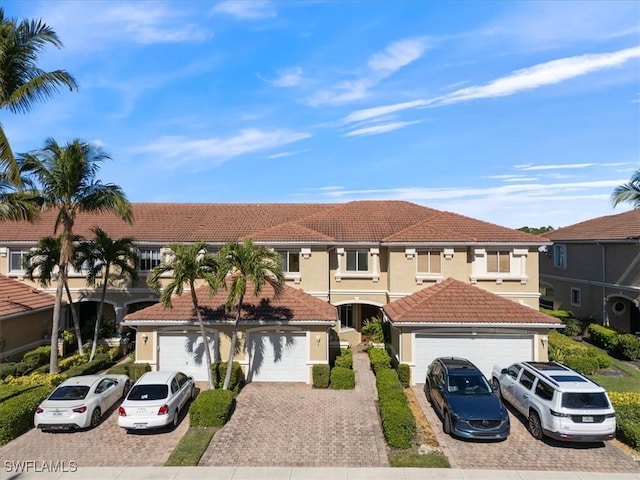 view of front of property with a tiled roof, driveway, and stucco siding