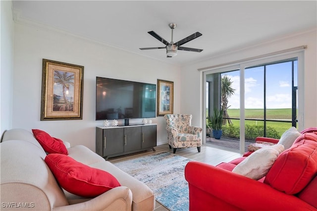 living room featuring light hardwood / wood-style flooring, ceiling fan, and ornamental molding