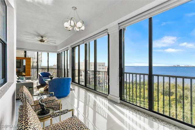 sunroom / solarium featuring ceiling fan with notable chandelier, a water view, and plenty of natural light