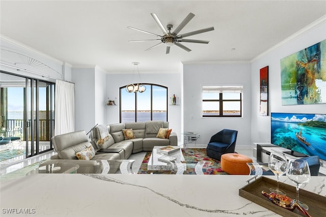 living room with ceiling fan with notable chandelier, a wealth of natural light, and crown molding