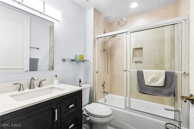 full bathroom featuring combined bath / shower with glass door, toilet, and vanity