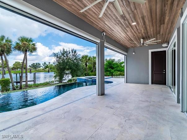 view of pool with ceiling fan and a water view