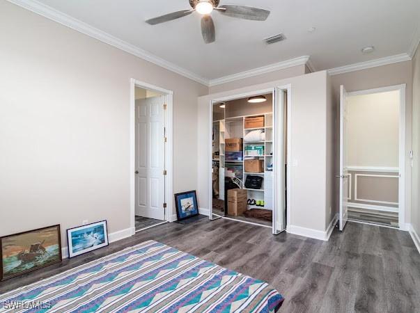 unfurnished bedroom with ceiling fan, dark wood-type flooring, and ornamental molding