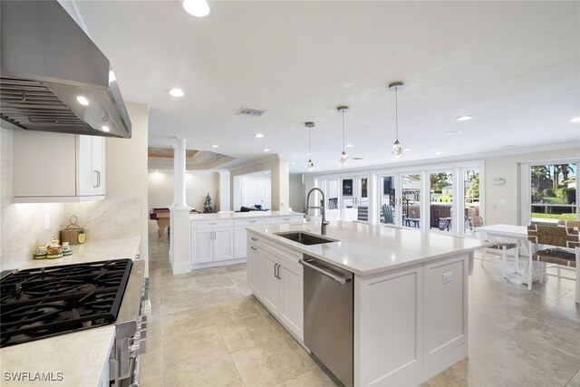 kitchen featuring extractor fan, pendant lighting, dishwasher, sink, and a center island with sink