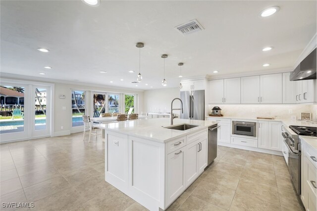 kitchen with pendant lighting, sink, white cabinets, a kitchen island with sink, and stainless steel appliances