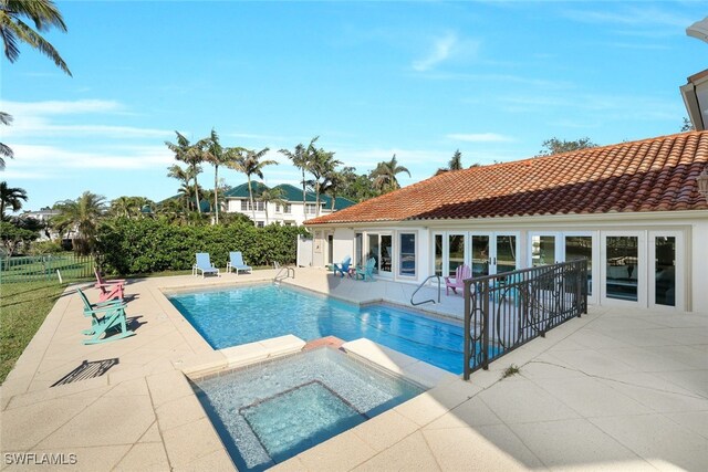 view of pool with an in ground hot tub and a patio