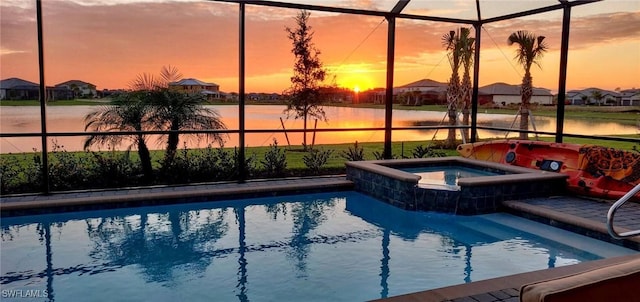 pool at dusk with a lanai, an in ground hot tub, and a water view