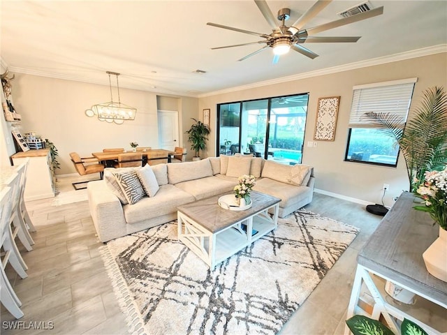 living room featuring ceiling fan with notable chandelier and crown molding