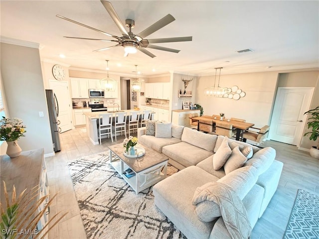 living room featuring crown molding, ceiling fan, and light hardwood / wood-style floors