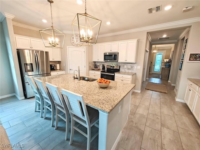 kitchen with white cabinets, sink, stainless steel appliances, and a kitchen island with sink