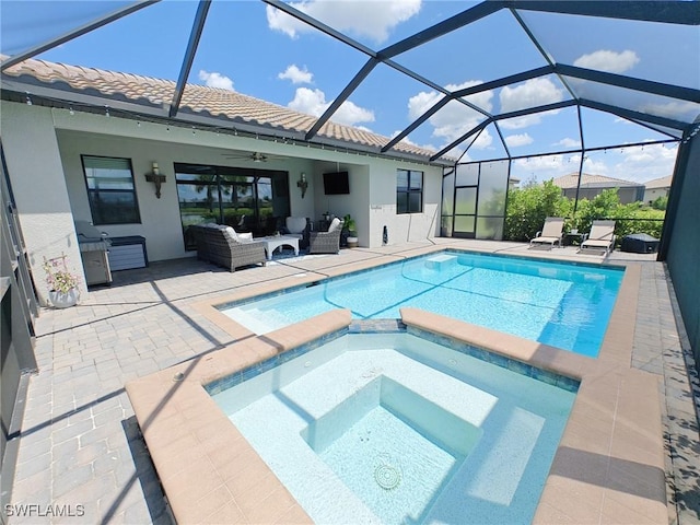 view of pool featuring glass enclosure, ceiling fan, an outdoor hangout area, a patio area, and an in ground hot tub