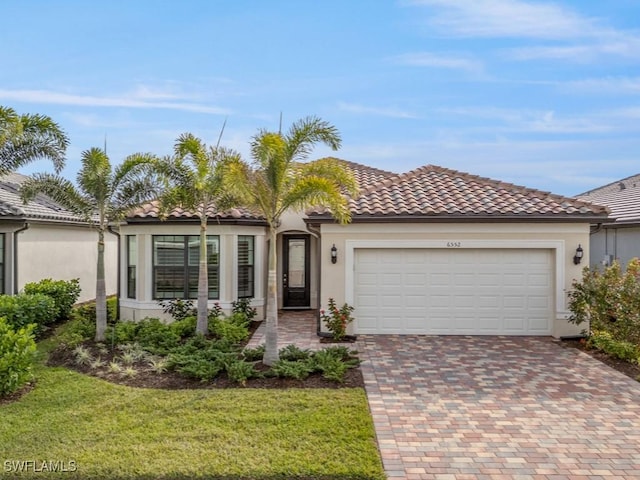 mediterranean / spanish-style house with a garage and a front lawn