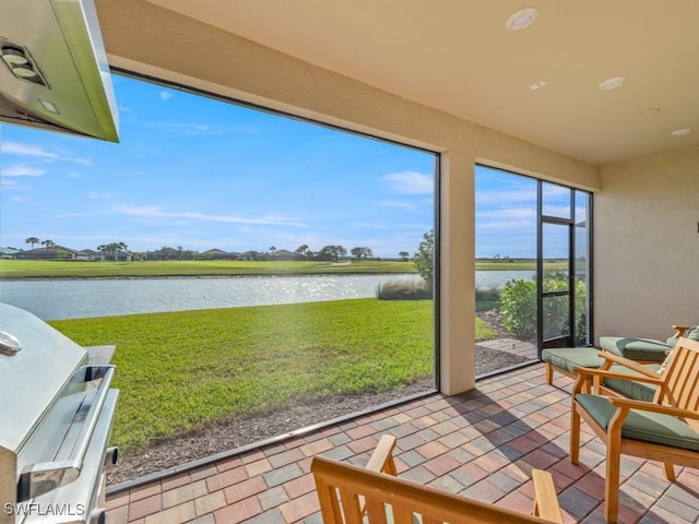 sunroom / solarium featuring a water view