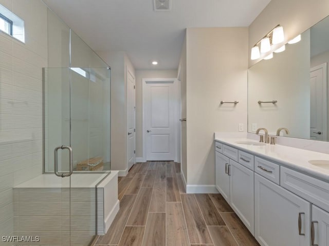 bathroom featuring vanity and a shower with shower door