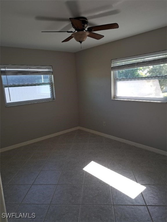 empty room featuring tile patterned flooring and ceiling fan