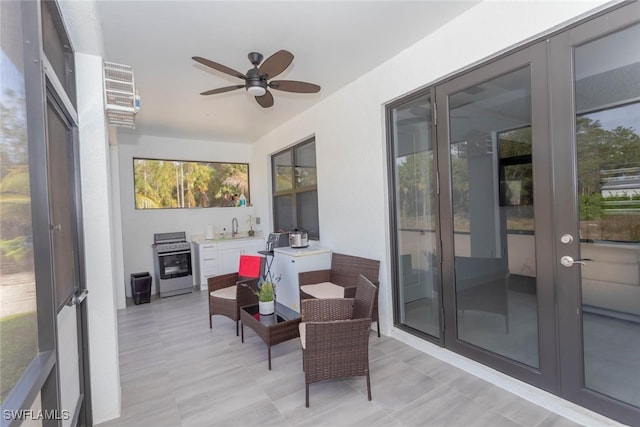 sunroom featuring ceiling fan and sink