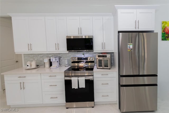 kitchen with decorative backsplash, white cabinets, and stainless steel appliances