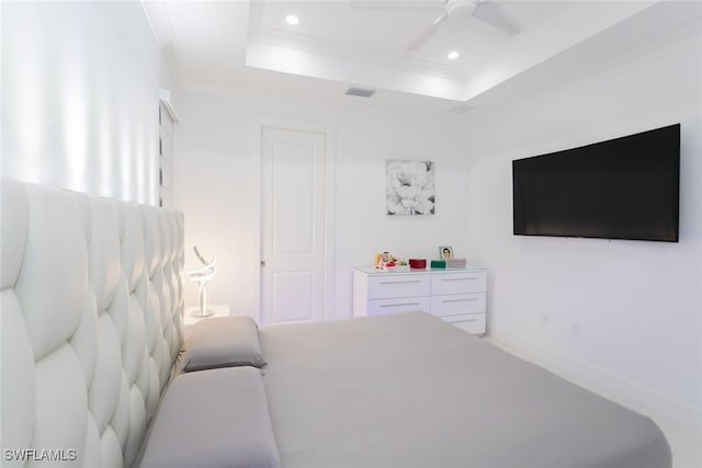 bedroom with a tray ceiling, ceiling fan, and crown molding