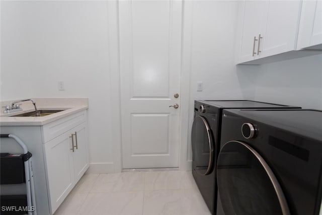 laundry room featuring cabinets, independent washer and dryer, and sink