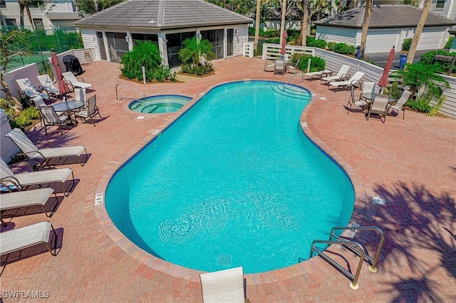 view of swimming pool featuring a patio area and a hot tub