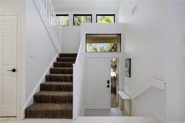 entrance foyer with tile patterned flooring and a high ceiling