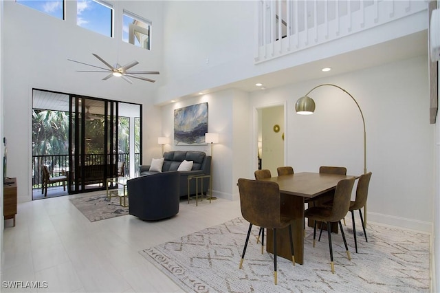 dining space featuring ceiling fan and a high ceiling