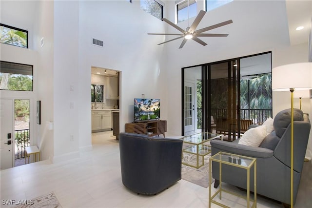 living room featuring ceiling fan and a high ceiling