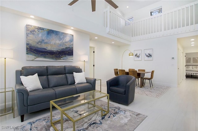 living room featuring a towering ceiling and ceiling fan