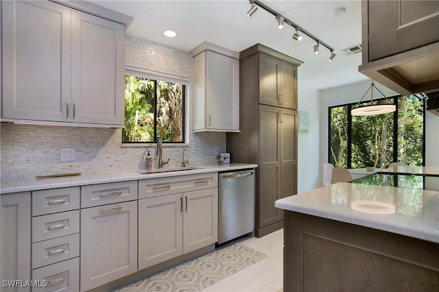 kitchen featuring backsplash, gray cabinets, dishwasher, and sink