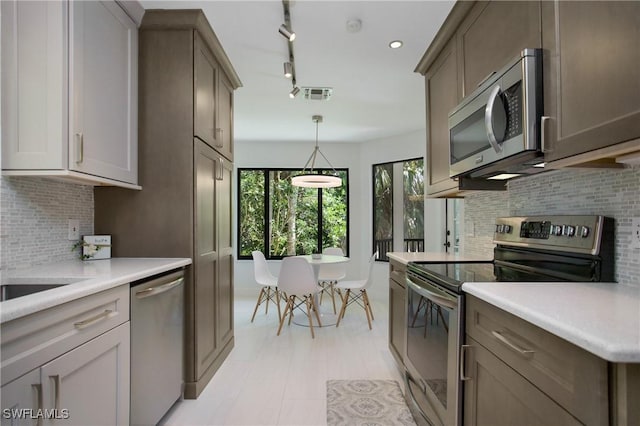 kitchen featuring tasteful backsplash, pendant lighting, and stainless steel appliances