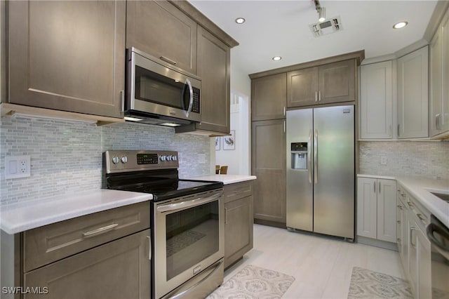 kitchen featuring appliances with stainless steel finishes, backsplash, and light tile patterned flooring