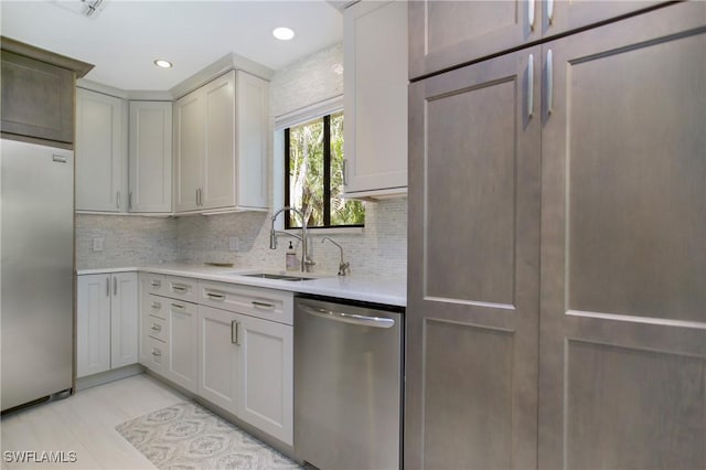 kitchen featuring decorative backsplash, appliances with stainless steel finishes, gray cabinets, and sink