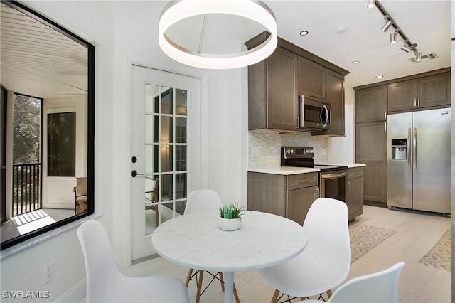 kitchen with decorative backsplash, dark brown cabinetry, stainless steel appliances, and light hardwood / wood-style flooring