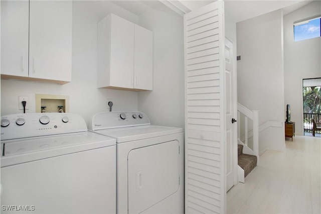 washroom with cabinets and washing machine and dryer