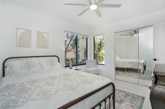 tiled bedroom with ceiling fan and a closet