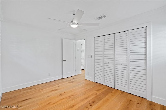 unfurnished bedroom with a closet, light wood-type flooring, visible vents, and baseboards