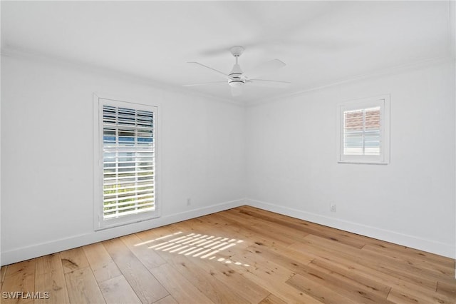 unfurnished room featuring ornamental molding, wood-type flooring, a ceiling fan, and baseboards