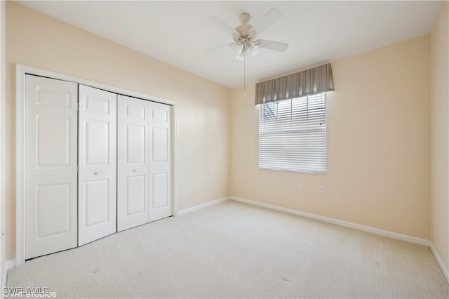 unfurnished bedroom featuring a closet, light colored carpet, and ceiling fan