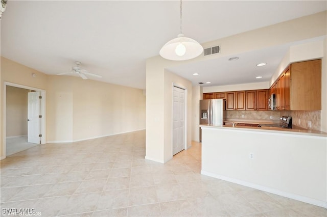 kitchen featuring appliances with stainless steel finishes, decorative backsplash, hanging light fixtures, ceiling fan, and light tile patterned floors