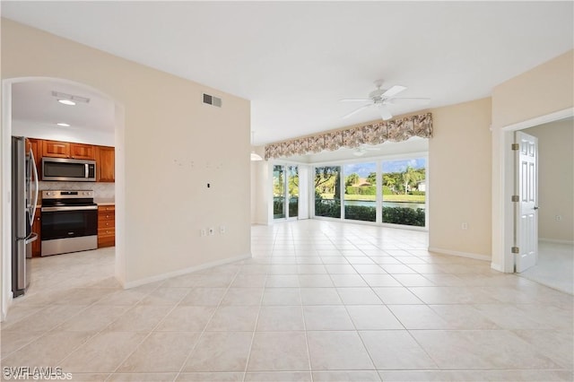 tiled spare room with ceiling fan